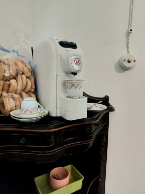 Machine à espresso avec tasses vintage sur meuble en bois foncé dans un appartement du Piémont, Italie