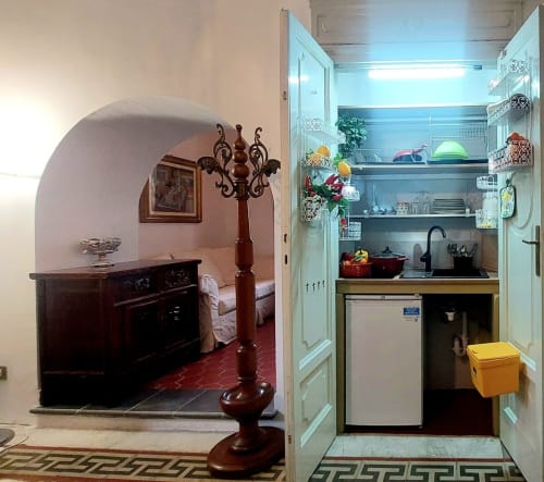 Appartement Palazzo Losio montrant alcôve chambre avec mobilier en bois et kitchenette équipée, Piémont Italie