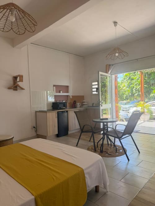 Studio Lagon au Kaz Kafe à Mamoudzou : chambre ouverte avec cuisine, coin repas et balcon vue mer