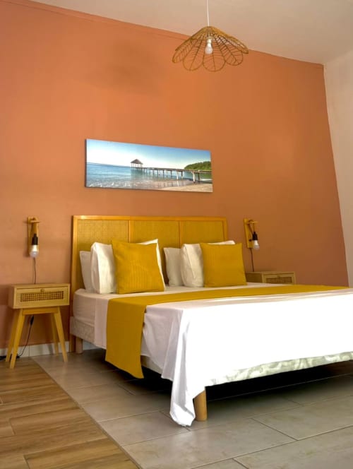 Chambre Studio Lagon du Kaz Kafe Mamoudzou avec lit jaune, vue sur la mer et mur accent orange