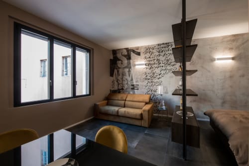Appartamento Sibilla Suite a Parma con divano beige, arredi moderni, opere d'arte e vista sulla città