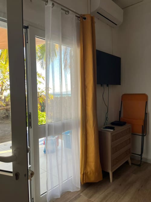 Chambre Studio Lagon de Kaz Kafe avec vue mer, TV, commode en bois et accès au jardin de palmiers à Mamoudzou