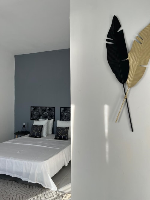 Studio Océan bedroom at Kaz Kafe with white bed, black feather wall art, minimalist décor in Mamoudzou
