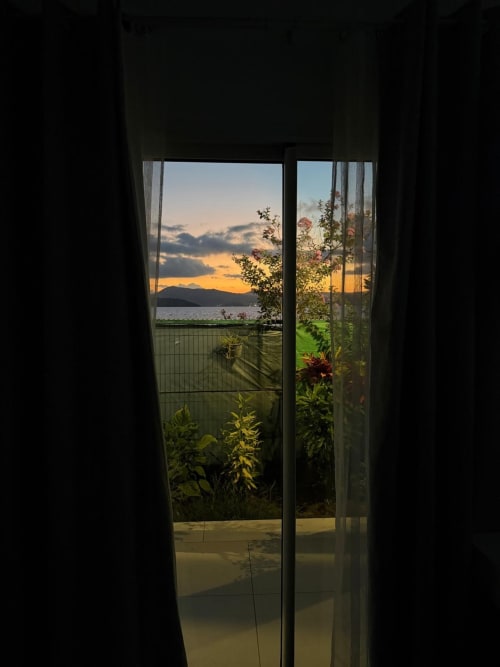 Studio Océan at Kaz Kafe Mamoudzou: sunset view over sea and mountains from glass doors