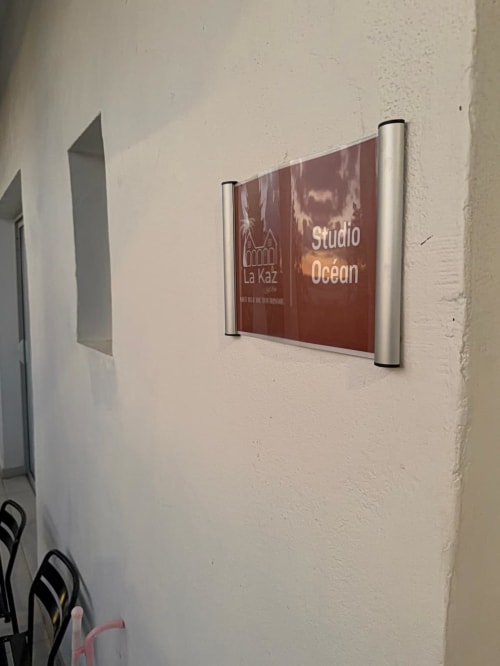 Studio Océan signage at Kaz Kafe bed and breakfast in Mamoudzou with red branding on white wall