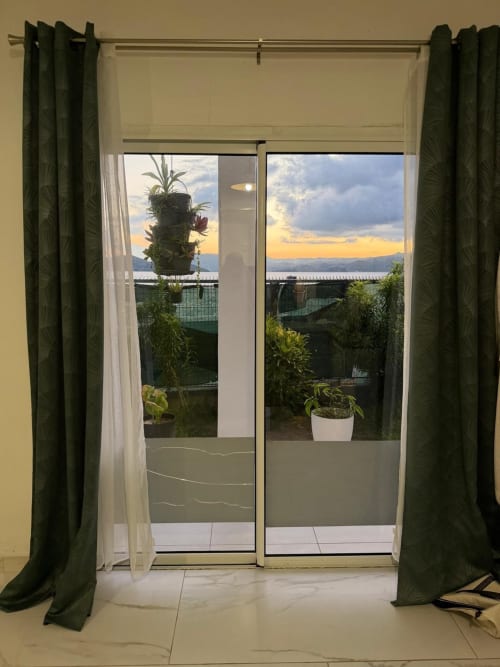 Studio Continent balcony doors at Kaz Kafe with sea view, potted plants, and sunset over Mamoudzou