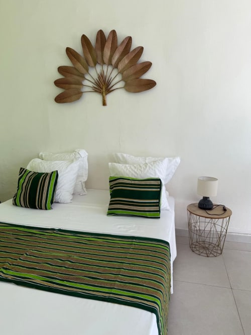Studio Continent bedroom at Kaz Kafe with striped bedding, white pillows, decorative wall art in Mamoudzou