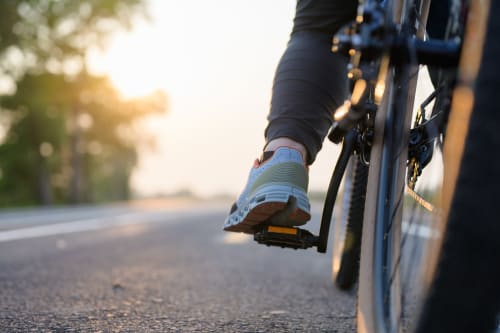 Cyclist's foot on pedal riding on sunny road near Casa Sibarita, Rafelguaraf