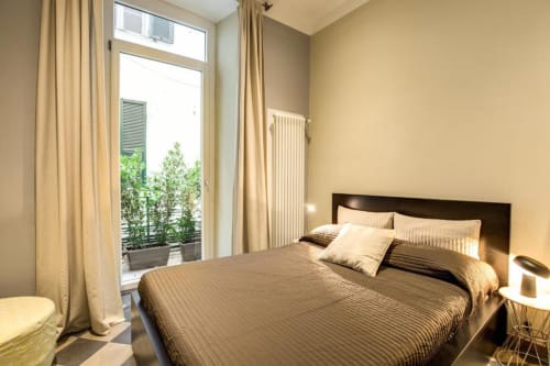 Camera moderna nell'appartamento Cavour Cinque Terre a Roma con letto queen, accesso al balcone e vista sulla città