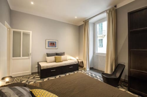 Camera da letto moderna in appartamento romano con letto gemello, finestra con vista sulla città e arredi contemporanei