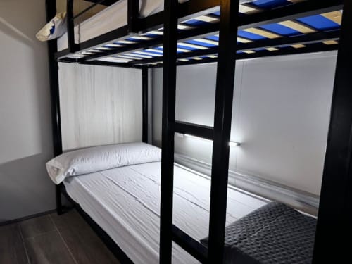 bunk beds in mixed dormitory at Albergue Santiago de Caminha hostel in Caminha, Portugal -Room in a mixed dormitory with air conditioning and Shared bathroom with shower. Tiled floor. Max occupancy: 1 person. Caminho Português da Costa - Camino de Santiago. Coastal way Senda Litoral
