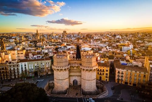 Torres de Serrano gate overlooking Valencia cityscape at golden sunset with historic architecture