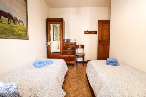 Camera doppia con arredamento in legno e asciugamani blu nell'appartamento Casa Pini, Auronzo di Cadore