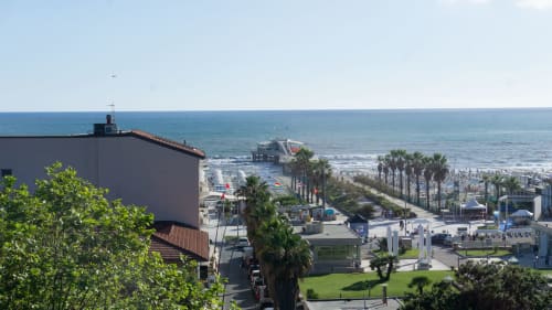 Versilia Panoramic Luxury penthouse view overlooking Tyrrhenian Sea beach, palm trees, and Como coastline
