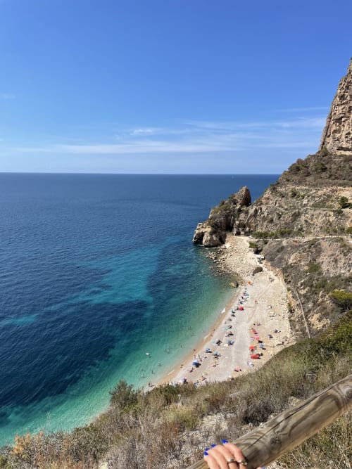 Scenic coastal beach cove at Casa Sibarita, Rafelguaraf, Spain with turquoise waters and rocky cliffs