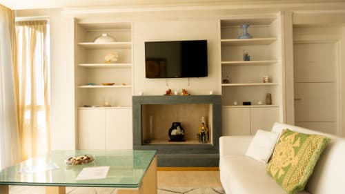 Luxury apartment living room with fireplace, built-in shelving, and flat-screen TV at Versilia Panoramic Hotel, COMO Italy