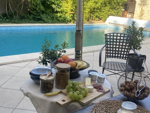 Petit-déjeuner au bord de la piscine du gîte Le Patio aux Oiseaux à La Ciotat avec charcuterie, pain et raisin frais