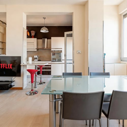 Modern open-plan living and kitchen at Roby's Panoramic House in Livorno with glass dining table and stainless steel
