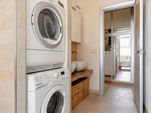 Laundry room with stacked washer and dryer at Roby's Panoramic House apartment in Viterbo