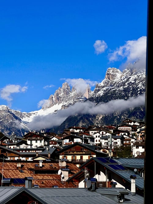 Montagne Dolomiti innevate sopra il villaggio alpino con caratteristici chalet, vista dall'appartamento di Auronzo di Cadore