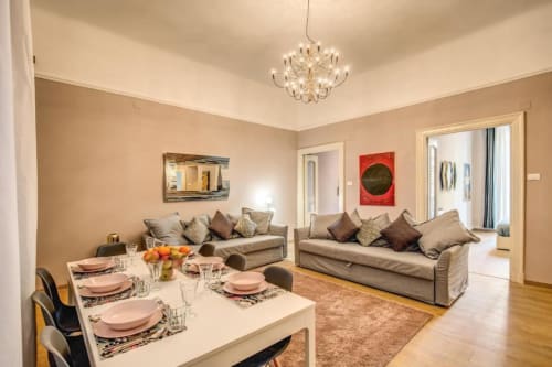 Modern living room and dining area in Cinque Terre New Liberty apartment, Roma with beige sofas, white dining table, and