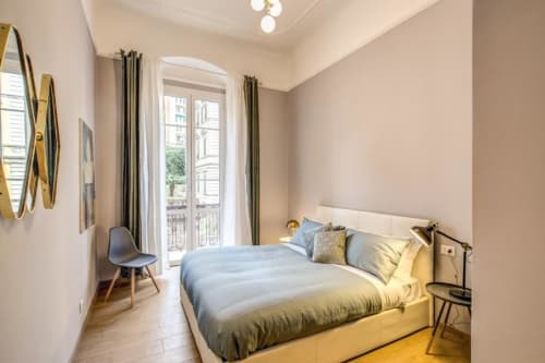 Modern bedroom in Cinque Terre New Liberty apartment, Rome with bed, balcony doors, hardwood floors