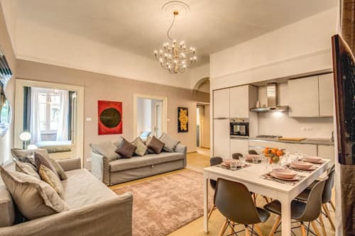 Modern Rome apartment living room with kitchen, dining area, comfortable seating, and chandelier