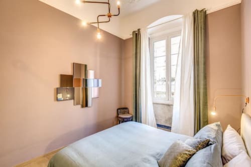 Modern bedroom in Cinque Terre New Liberty apartment with bed, balcony doors, green curtains, and contemporary wall art in