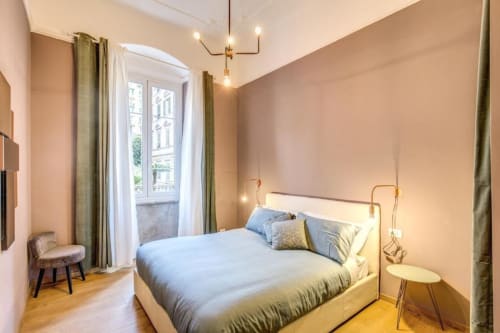 Modern bedroom in Cinque Terre New Liberty apartment in Rome with queen bed, brass headboard, green curtains, and balcony