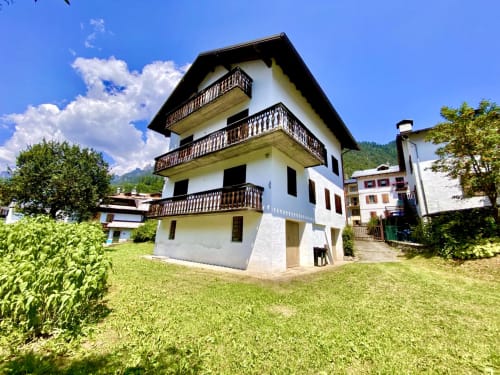 Residence alpina ad Auronzo di Cadore con balconate, vista montagna, prato verde e accesso al lago