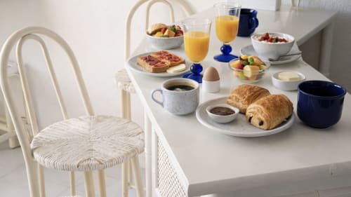 Desayuno continental en Holidays Costa Brava con cruasanes, zumo, café y frutas frescas sobre mesa blanca
