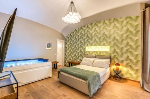 Lussuosa camera da letto romana con carta da parati a felci verdi, letto matrimoniale, vasca idromassaggio e illuminazione moderna