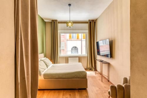 Camera da letto moderna nell'appartamento Croce di Malta Royale a Roma con letto, TV e vista dalla finestra