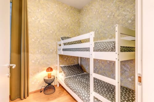 Letti a castello bianchi con biancheria a motivi nella camera da letto dell'appartamento Downtown Srl a Roma, Italia