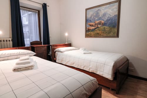 Spaziosa camera da letto con letti gemelli ad Auronzo di Cadore, opere d'arte montane e comfort moderni vicino al lago