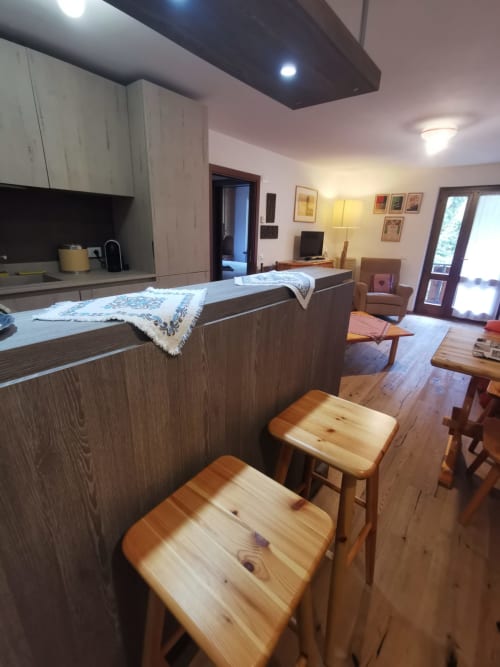 Cucina e zona living open-space moderna ad Auronzo di Cadore, Dolomiti, con bancone in legno