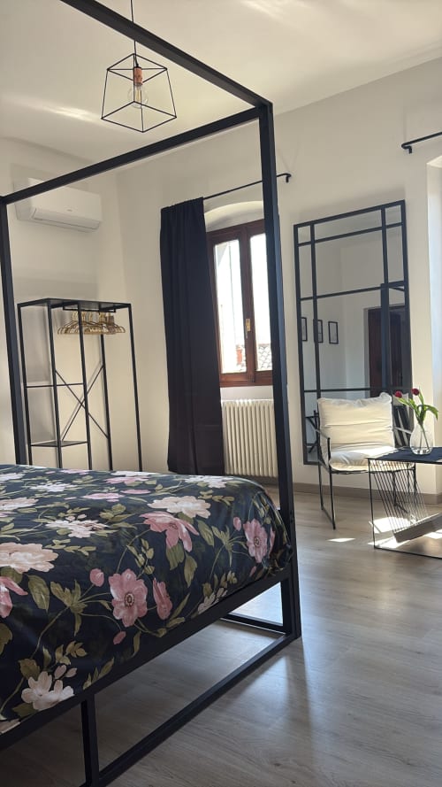 Camera moderna a La Dolce Casa B&B a Cremia con letto a quattro colonne nero, biancheria floreale, vista sul lago e arredamento contemporaneo