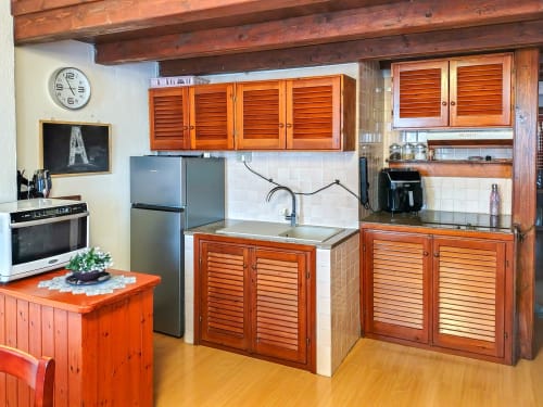 Rustic kitchen in Dolce Sardinia apartment at Vesta Home Rent, Padova featuring wooden cabinets, stainless refrigerator, and