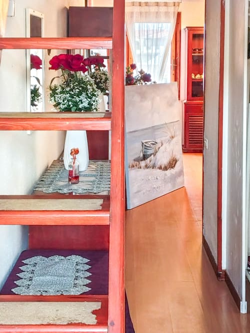 Vesta Home Rent Dolce Sardinia apartment in Padova with red shelving, flowers, and beach-themed decor