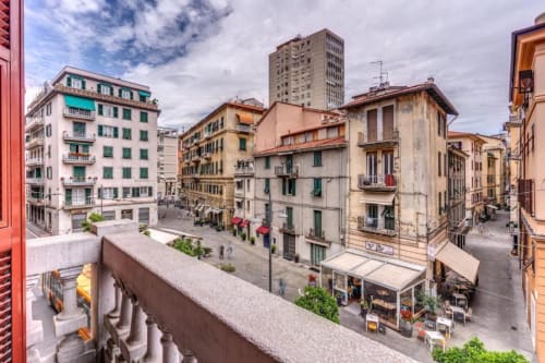 Balcony view of historic Roma city square with colorful buildings, shops, and pedestrians at Cinque Terre Dream apartment