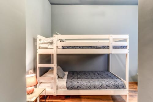 White wooden bunk bed with blue patterned mattresses in modern Rome apartment bedroom