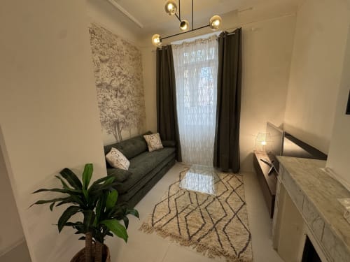 Cosy cottage studio in Bouc Bel Air with sofa, modern pendant lights, potted plant, and city view