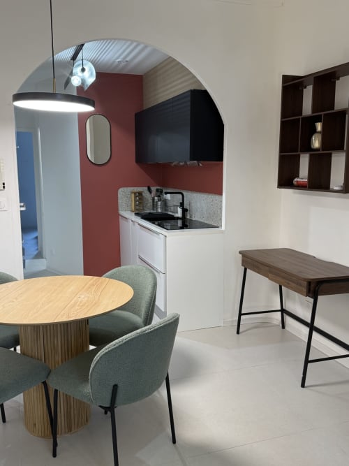 Kitchenette moderne avec coin repas à la Cosy Cottage By Alice, Bouc Bel Air, avec table en bois, chaises vertes et