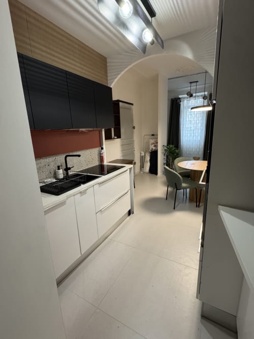 Modern kitchen and dining area in Cosy cottage by Alice, Bouc Bel Air, featuring white cabinetry and terrazzo backsplash