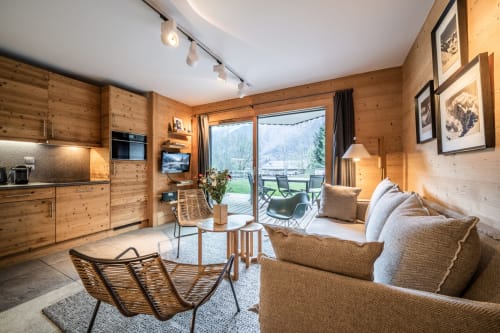 Warm wooden apartment at Le Chalet Mont-Blanc with living area, kitchen, and mountain views from balcony in Les Houches