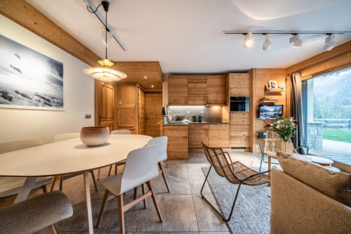 Modern alpine apartment at Le Chalet Mont-Blanc with wooden kitchen, dining area, and mountain views in Les Houches