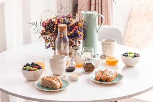 Petit-déjeuner raffiné aux Instants Volés avec viennoiseries, fruits frais, jus et fleurs séchées à Tudeils