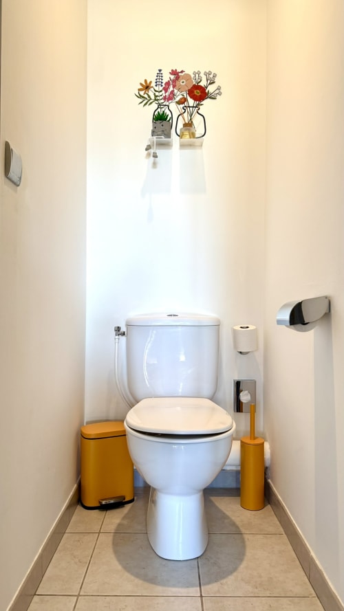 Modernes weißes Toilettenbecken mit cremefarbenem Sitz im Studio-Badezimmer der Résidence Château des Artistes in Cannes mit Gelb