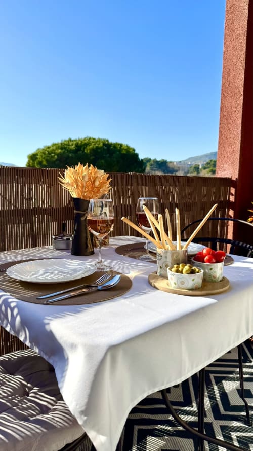 Eleganter Esstisch auf der Terrasse der Résidence Château des Artistes in Cannes, gedeckt mit Vorspeisen und Wein