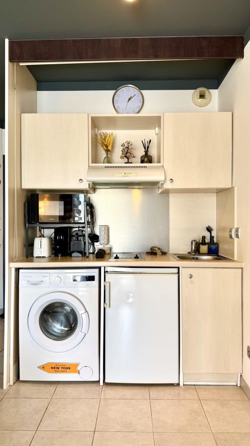 Kompakte Studio-Kitchenette mit Waschmaschine, Mikrowelle und Kochfeld in der Résidence Château des Artistes in Cannes